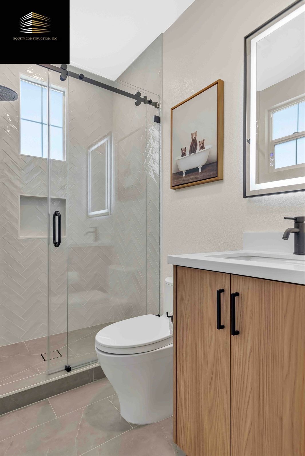 Modern bathroom with glass shower, wooden vanity, and artwork.