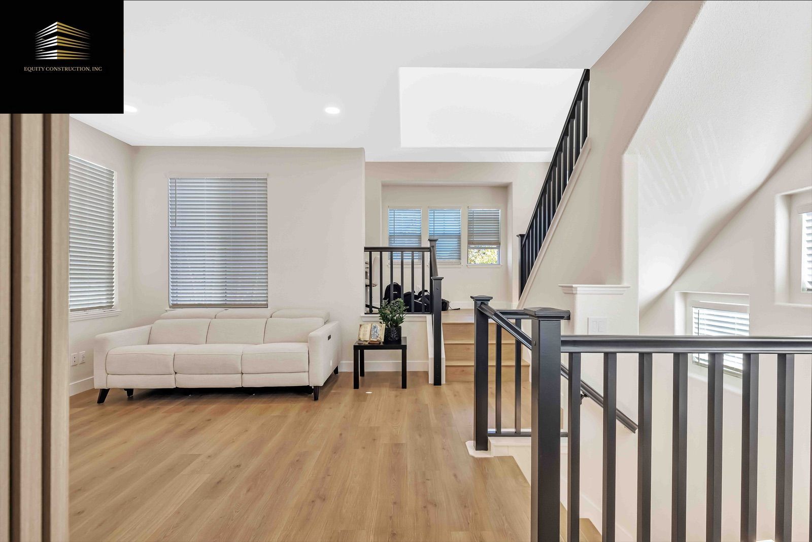 Modern gray-tiled shower with glass door, black fixtures, built-in bench, and small window.