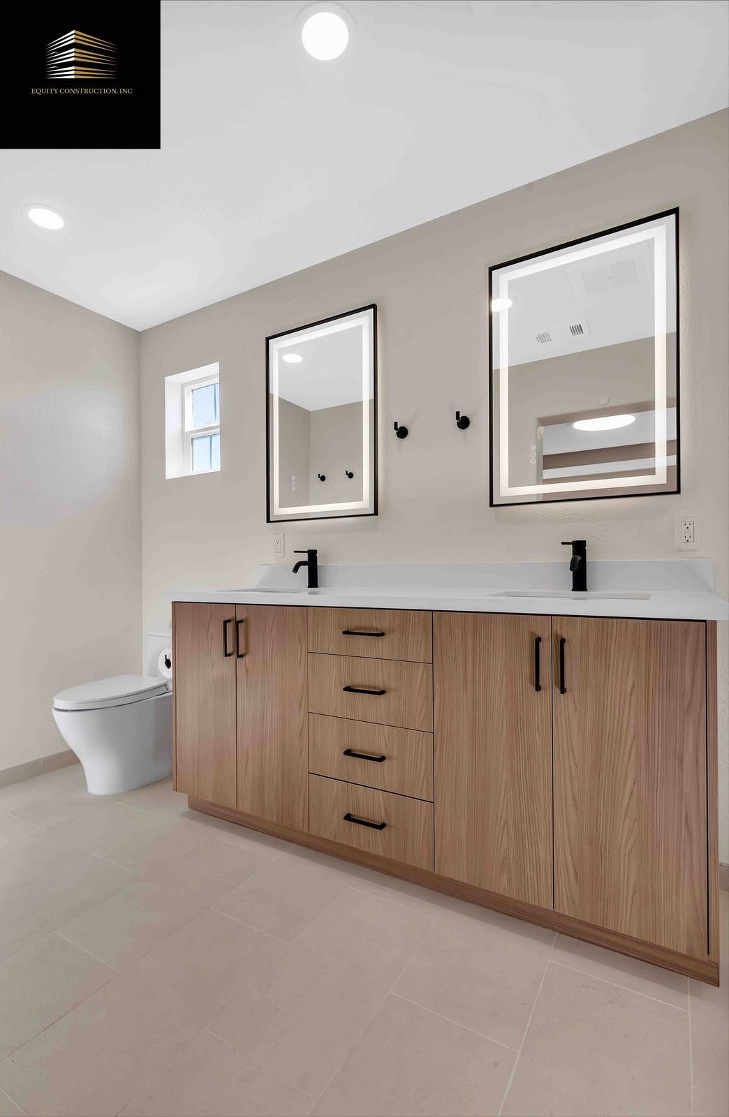 Modern bathroom with double vanity, backlit mirrors, and wooden cabinets.