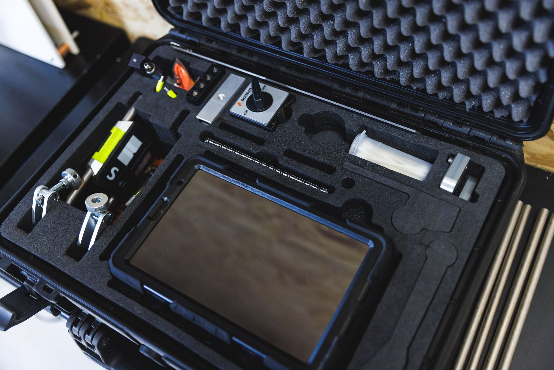 Une mallette noire remplie d'outils et d'une tablette.