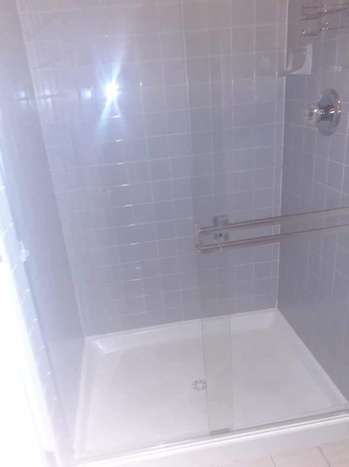 A shower stall with a glass door in a bathroom.