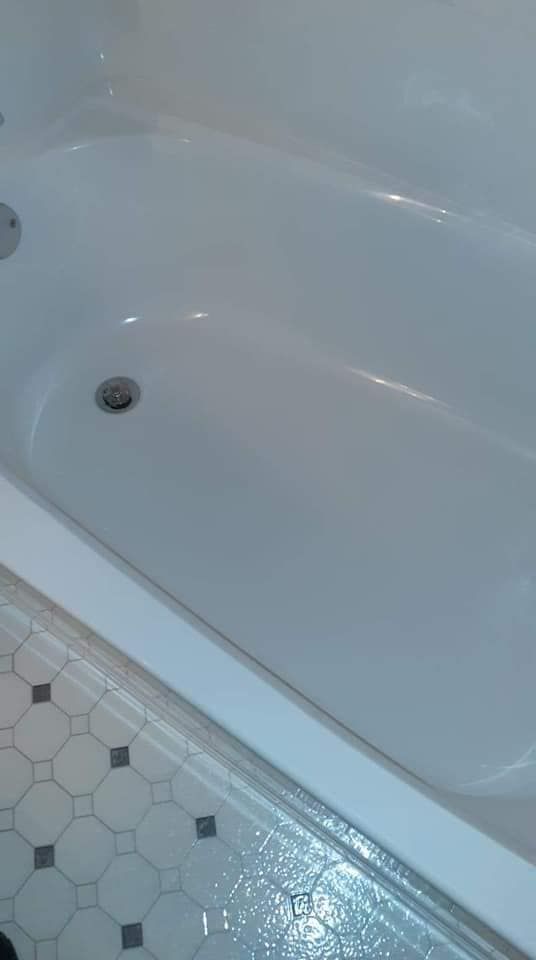A white bathtub is sitting on a tiled floor in a bathroom.
