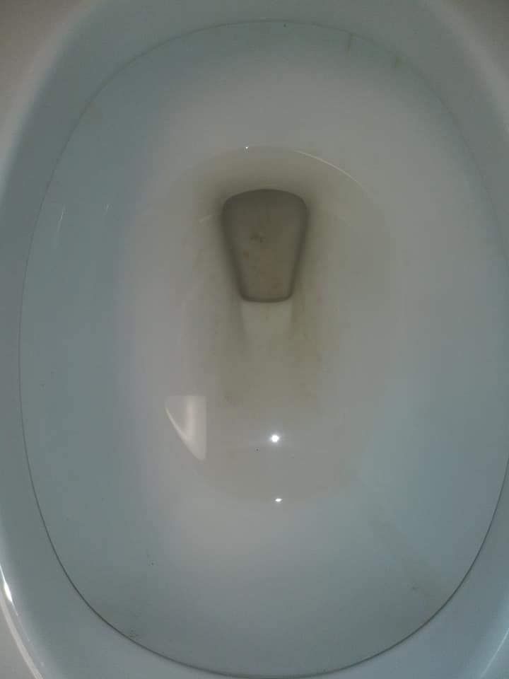 A close up of a toilet bowl with water in it.