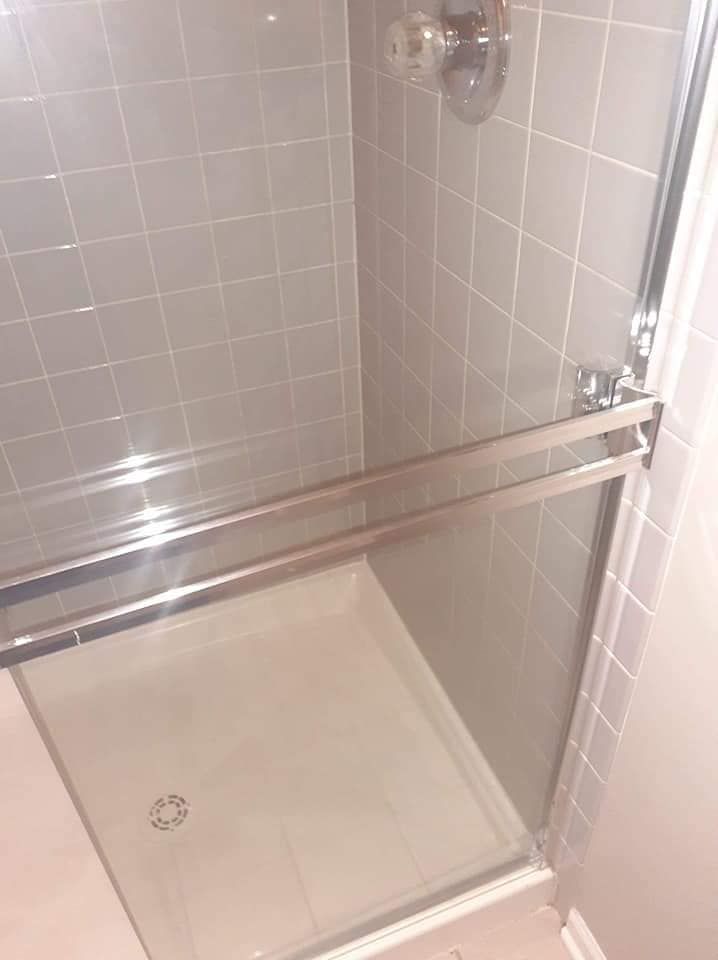 A shower stall with a glass door in a bathroom.
