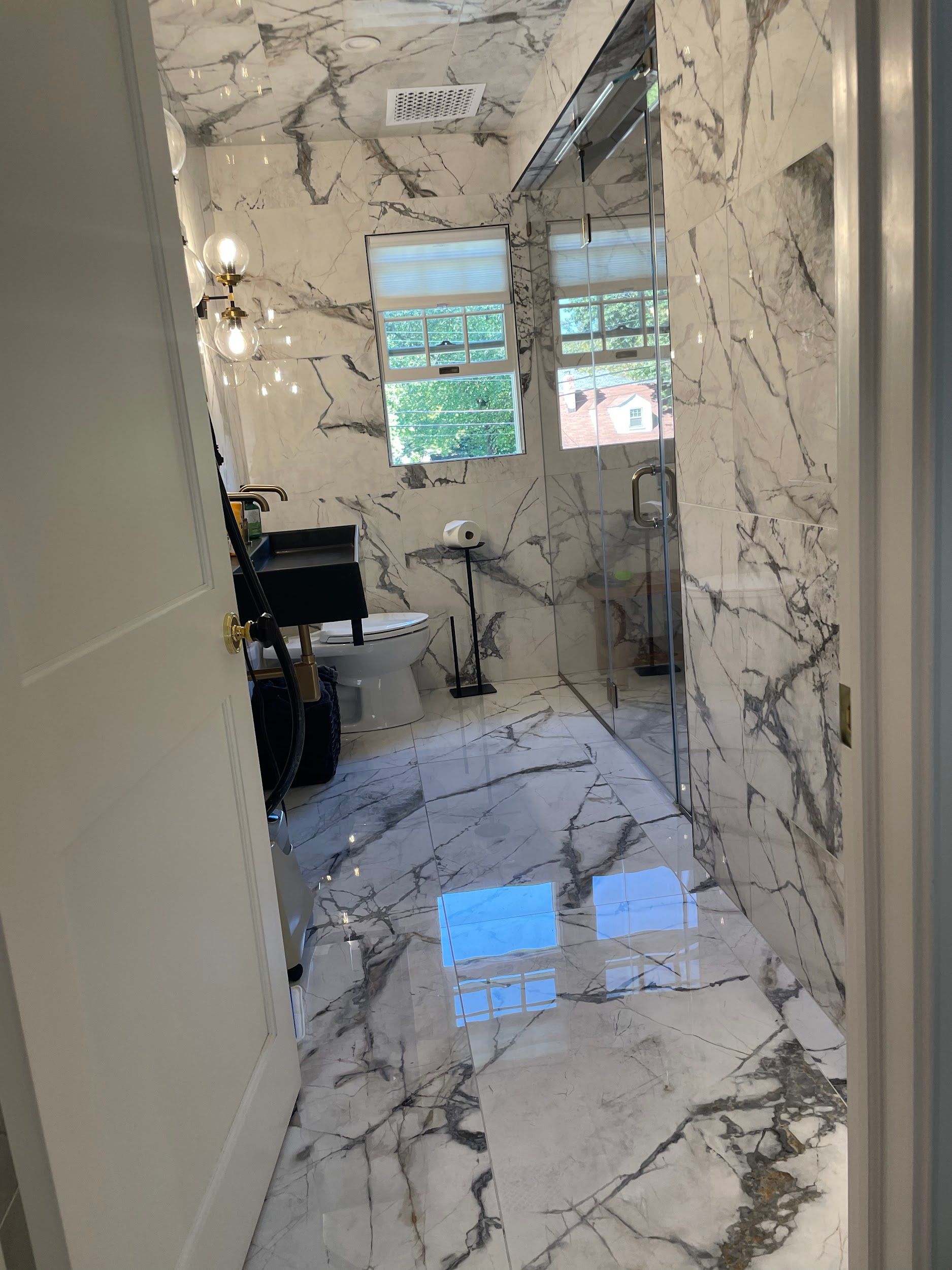 A bathroom with marble tiles on the floor and walls.