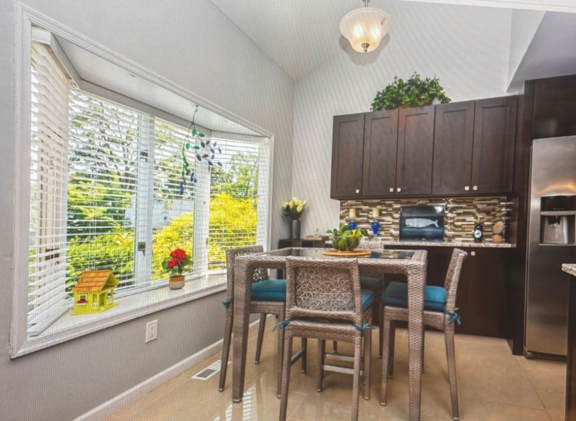 A kitchen with a table and chairs in front of a window.