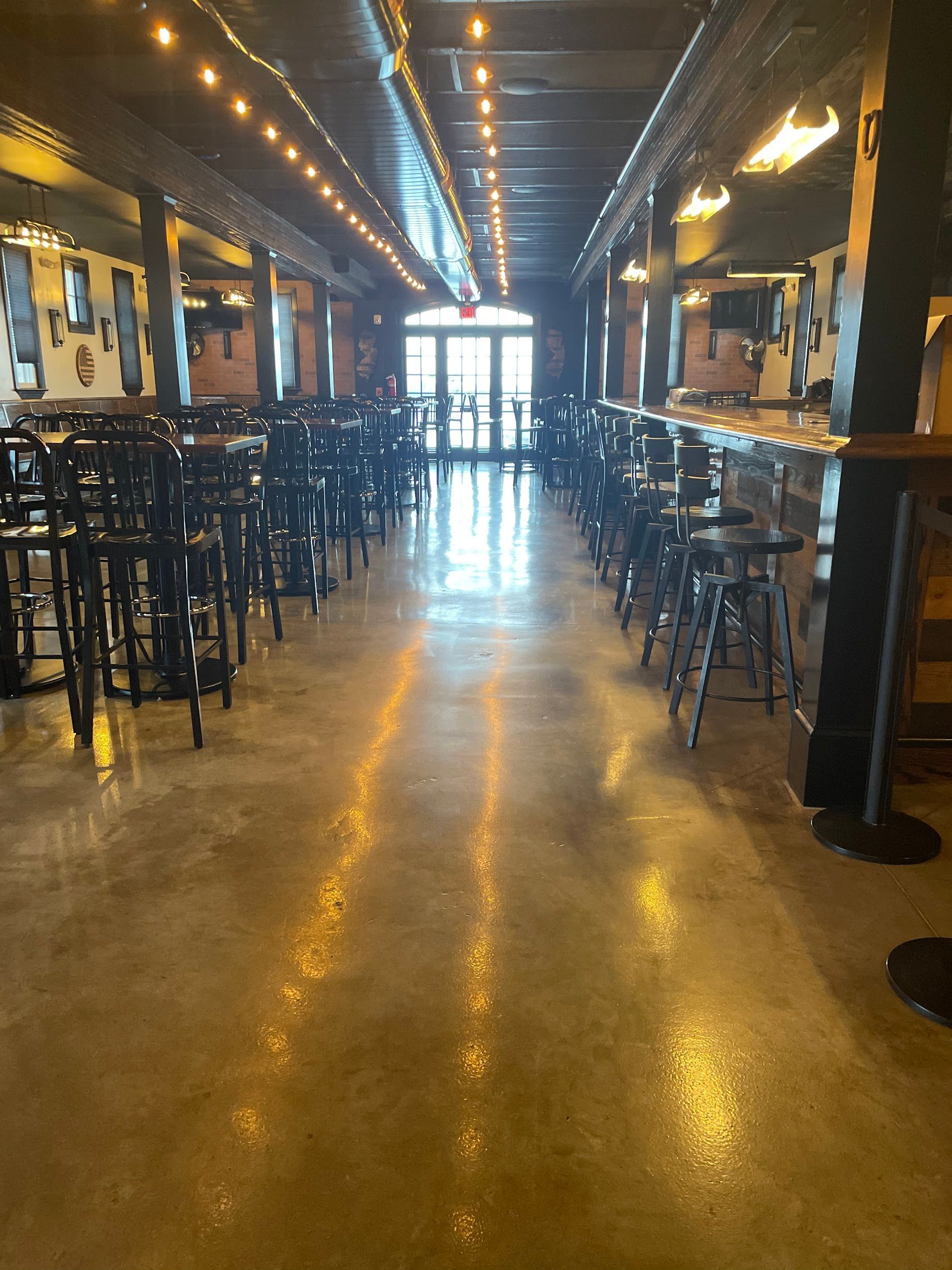 A long hallway with tables and chairs in a restaurant