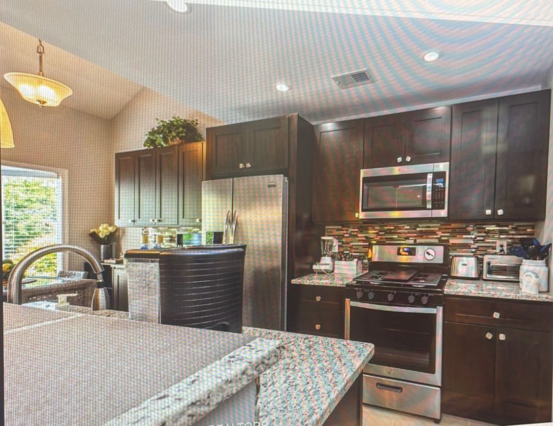 A kitchen with stainless steel appliances and granite counter tops.