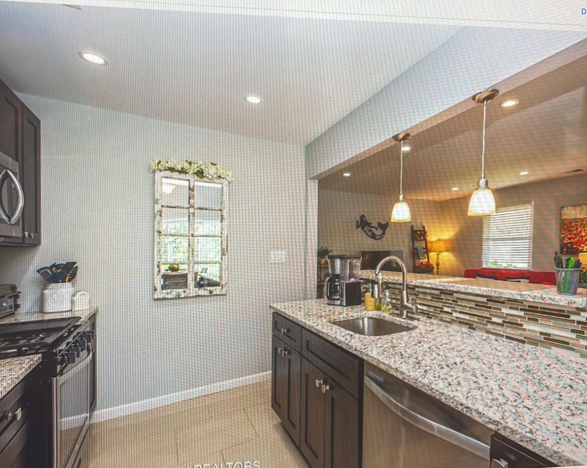 A kitchen with granite counter tops and stainless steel appliances