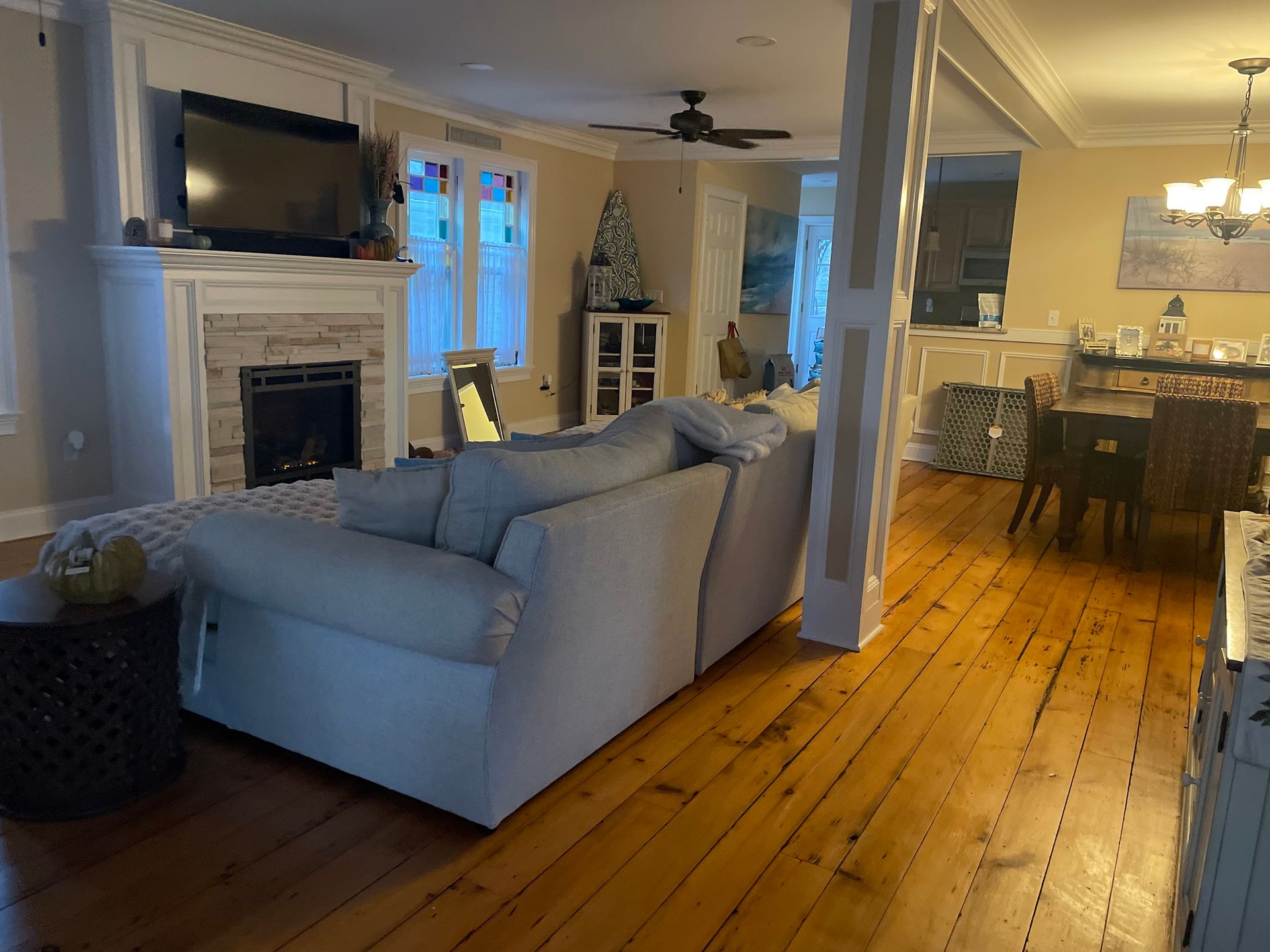 A living room with a couch , fireplace and television.