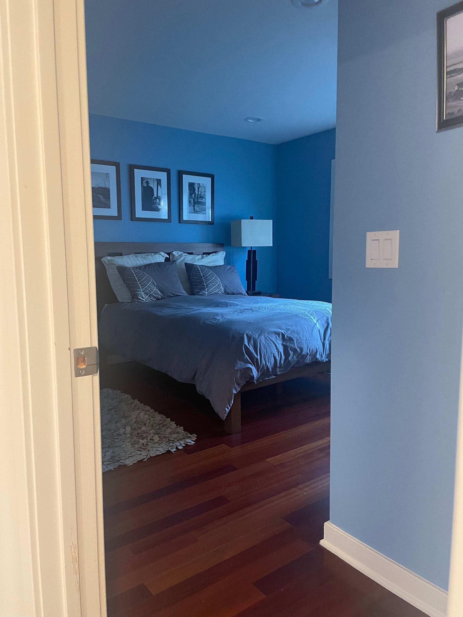 A bedroom with blue walls and a large bed