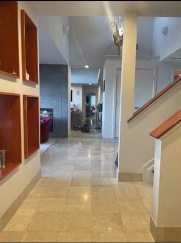 A hallway in a house with stairs and shelves