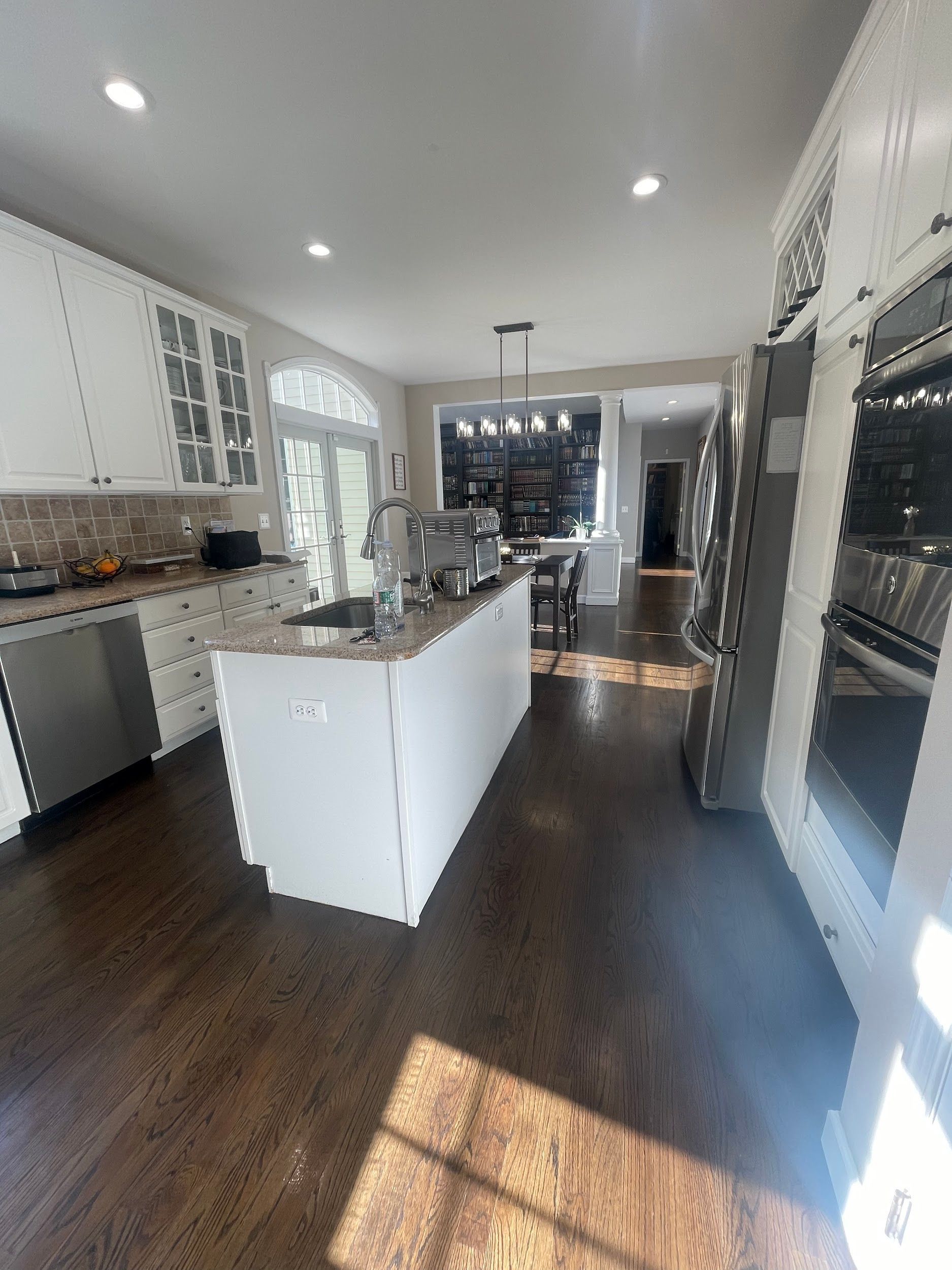 A kitchen with stainless steel appliances and a large island in the middle.