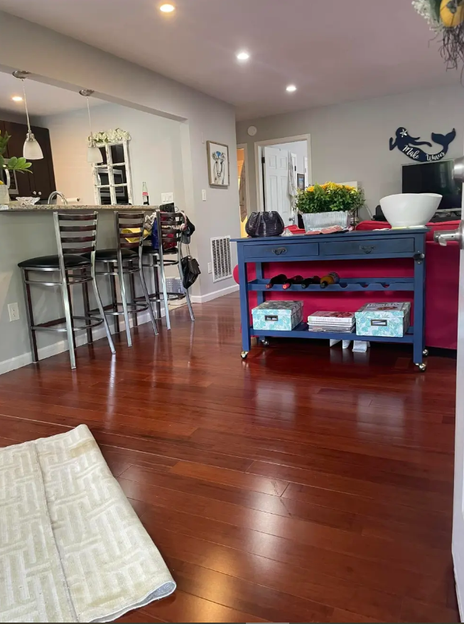 A living room with hardwood floors and a blue table.