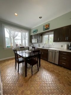 Kitchen with dark wood cabinets, table with chairs, and patterned floor.