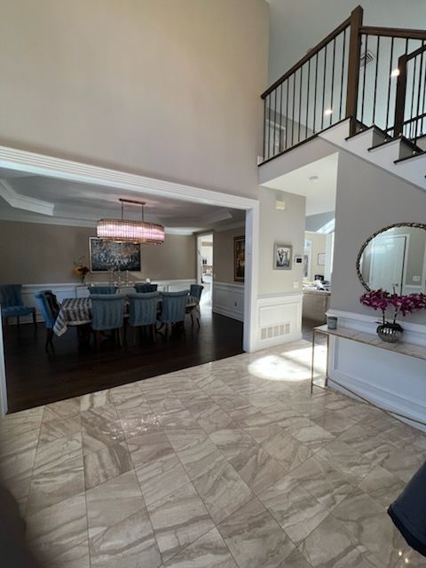 Spacious entry with tile floor, dining room, staircase, and neutral walls.