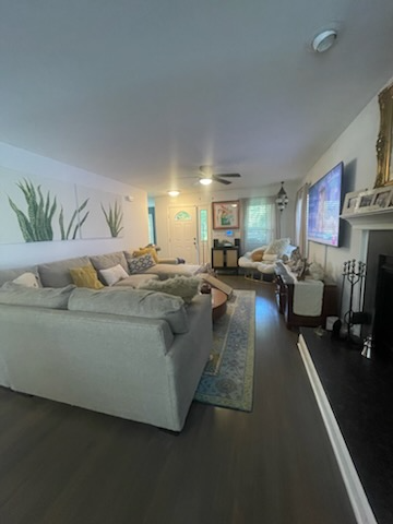 Spacious living room with a large sectional sofa, artwork, and TV. Natural light fills the space.