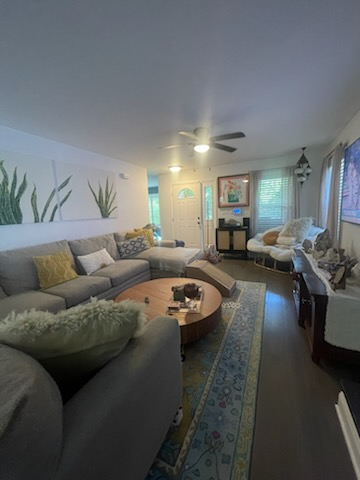 Cozy living room with gray sectional, round coffee table, artwork, and a rug; light-filled space.