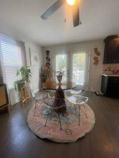 Dining room with round table, clear chairs, and a pink and blue rug on dark wood floors.