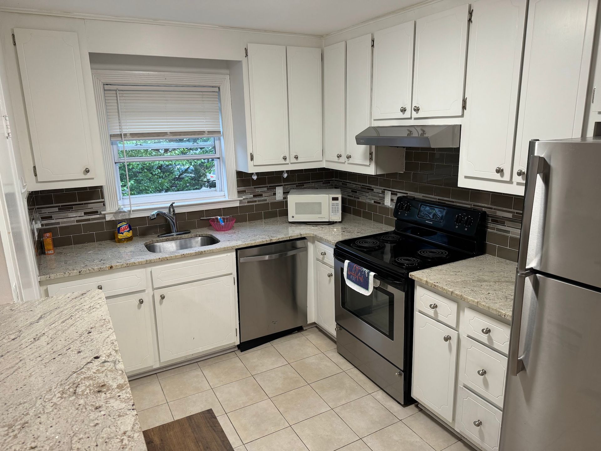 A kitchen with white cabinets and stainless steel appliances