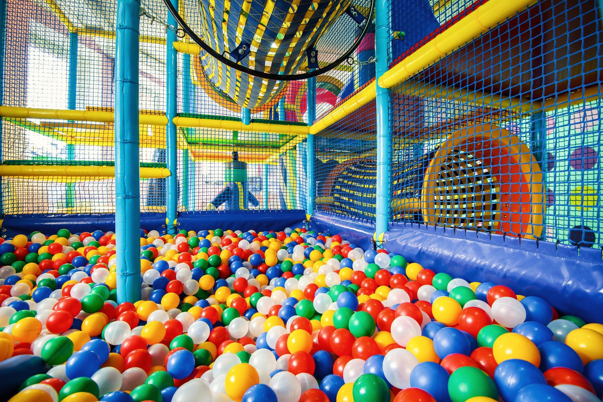 Colorful ball pit inside a children's play structure with slides and climbing areas.