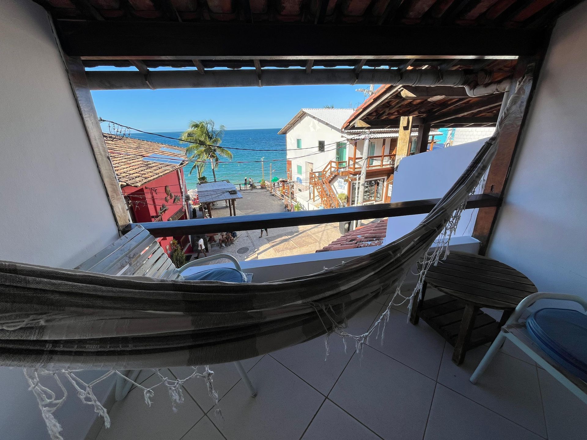 Uma rede está colocada em uma varanda com vista para o oceano.