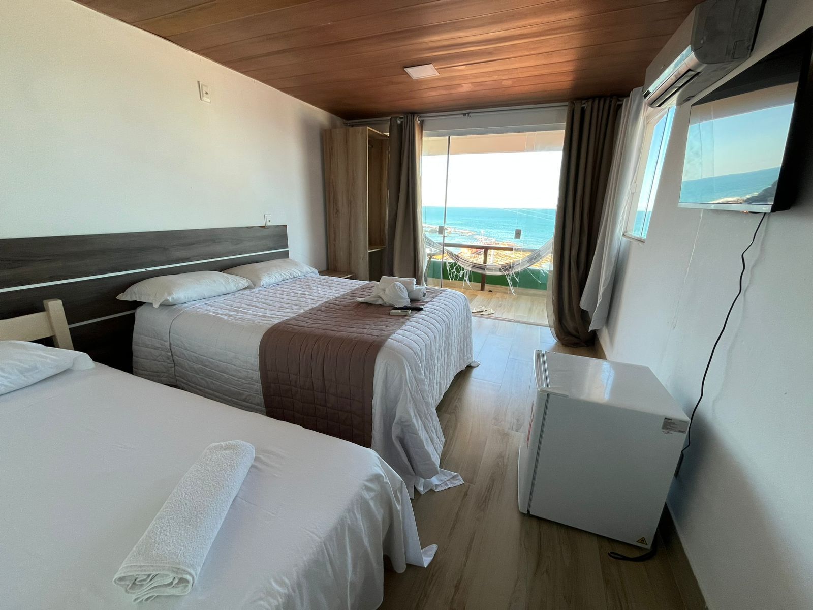 Um quarto de hotel com duas camas e uma varanda com vista para o oceano.