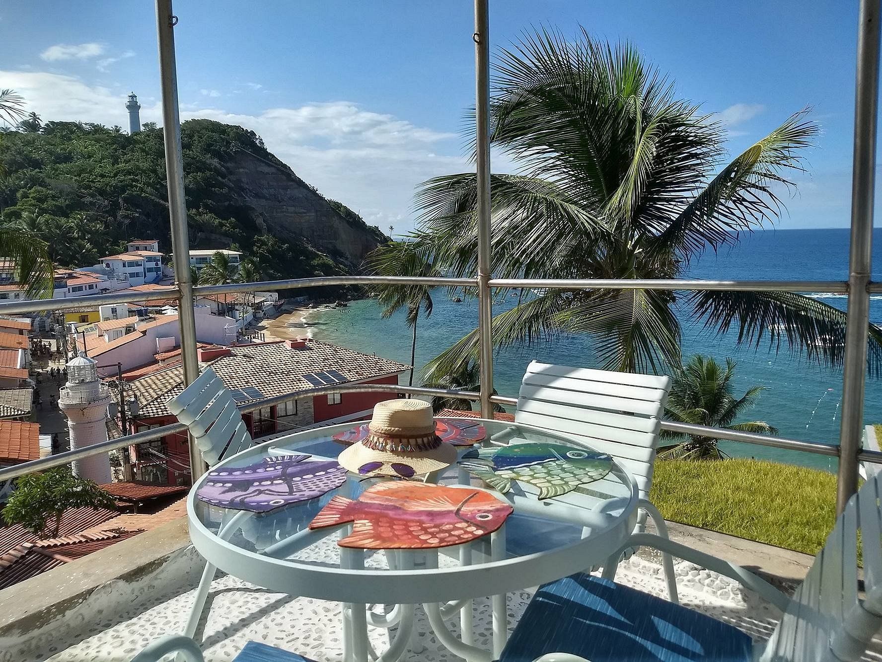 Uma mesa e cadeiras em uma varanda com vista para o oceano.