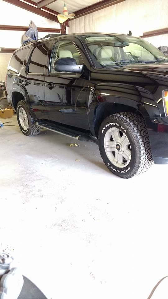 A black suv is parked in a garage.
