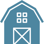 A blue barn with squares on the roof and a white door.