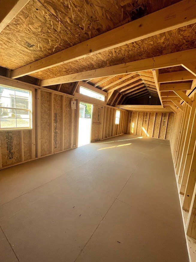 A large empty room with a wooden ceiling and a lot of windows.