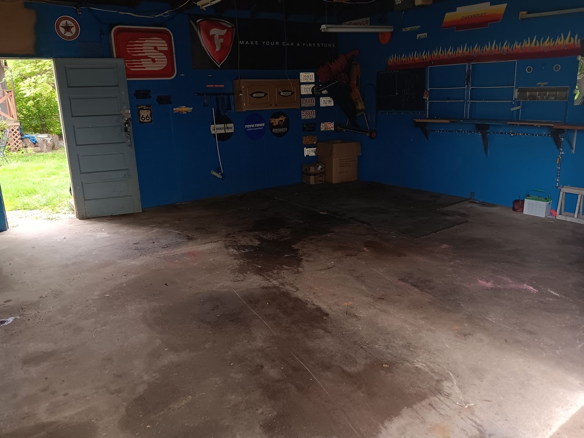 A blue garage with a lot of tools on the wall.