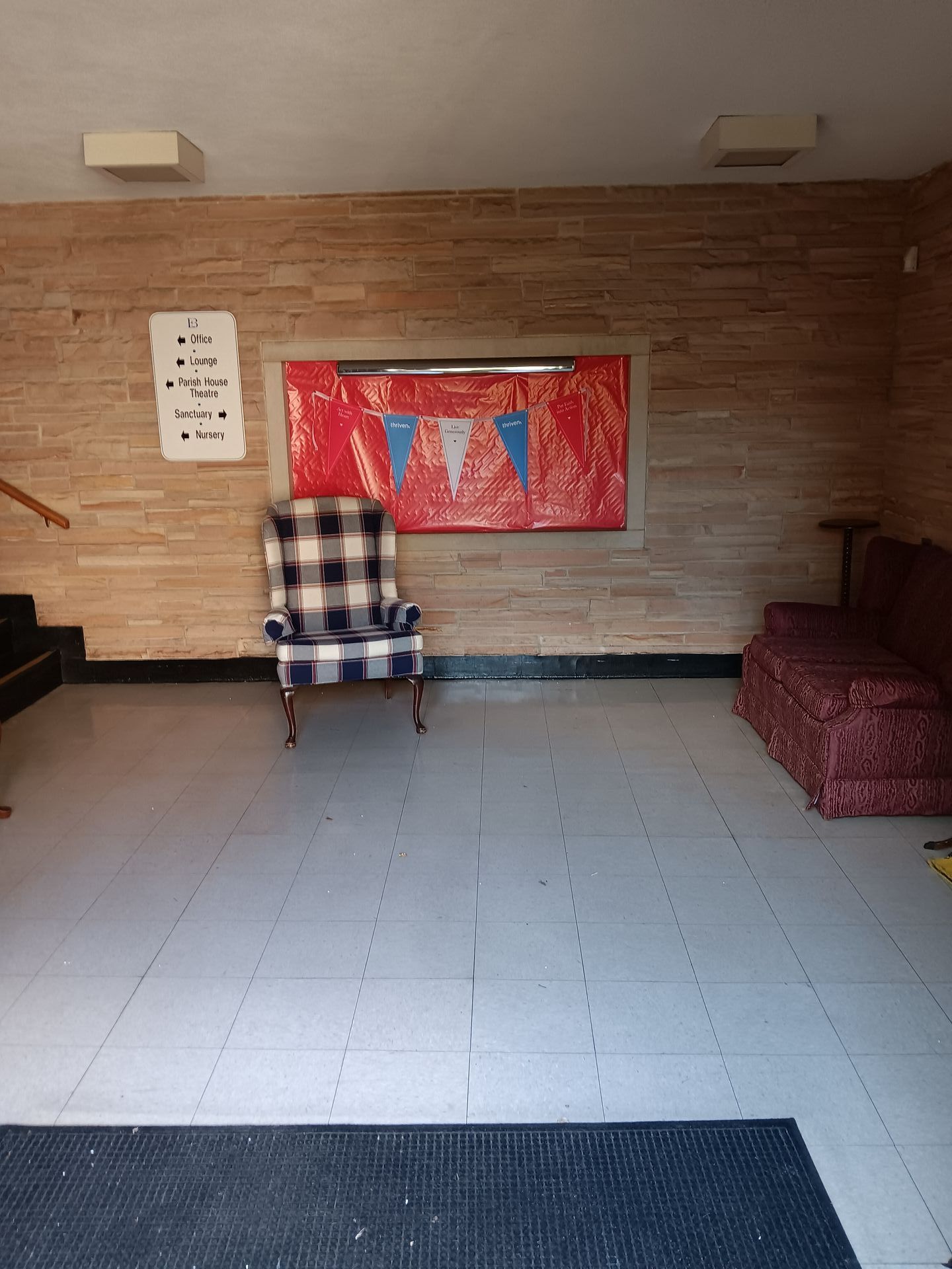 An empty room with a chair and a painting on the wall