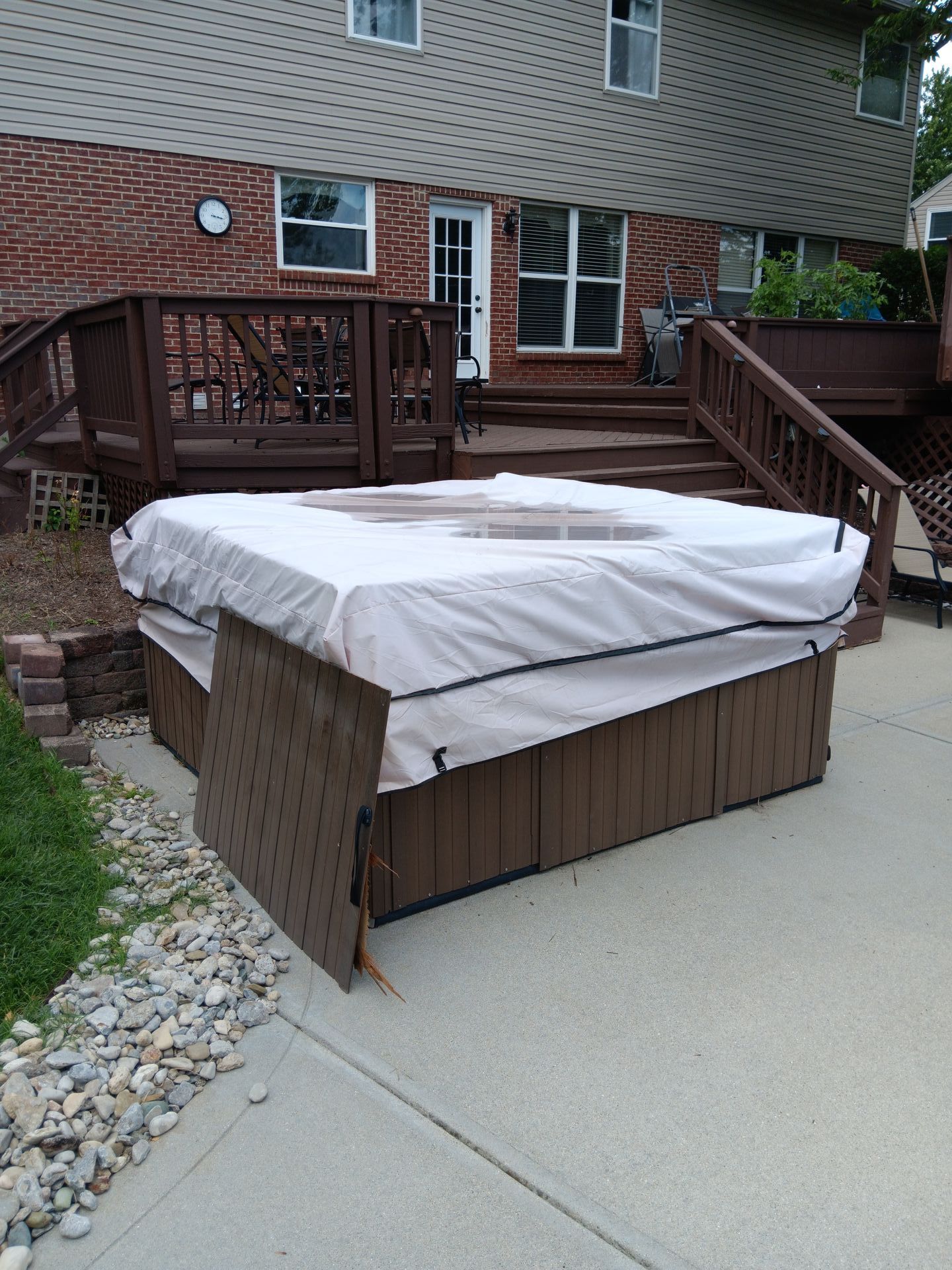 A hot tub is sitting on the sidewalk in front of a house