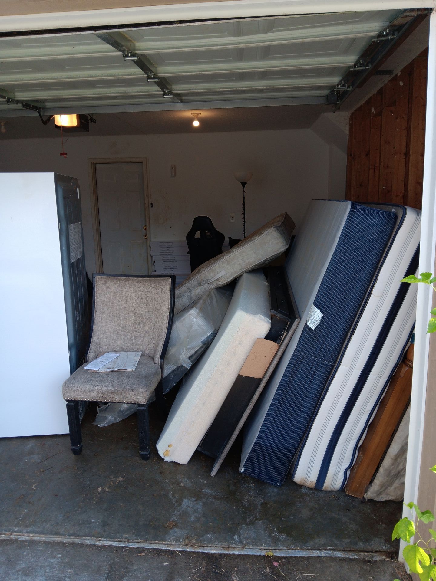 A garage filled with mattresses and a chair