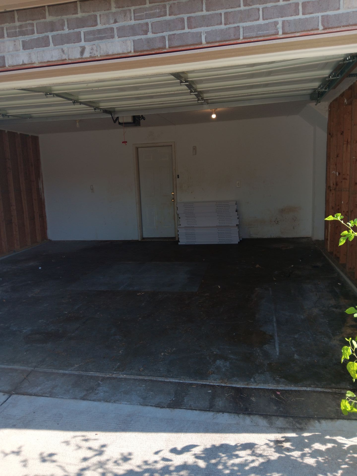 An empty garage with a brick wall and a white door