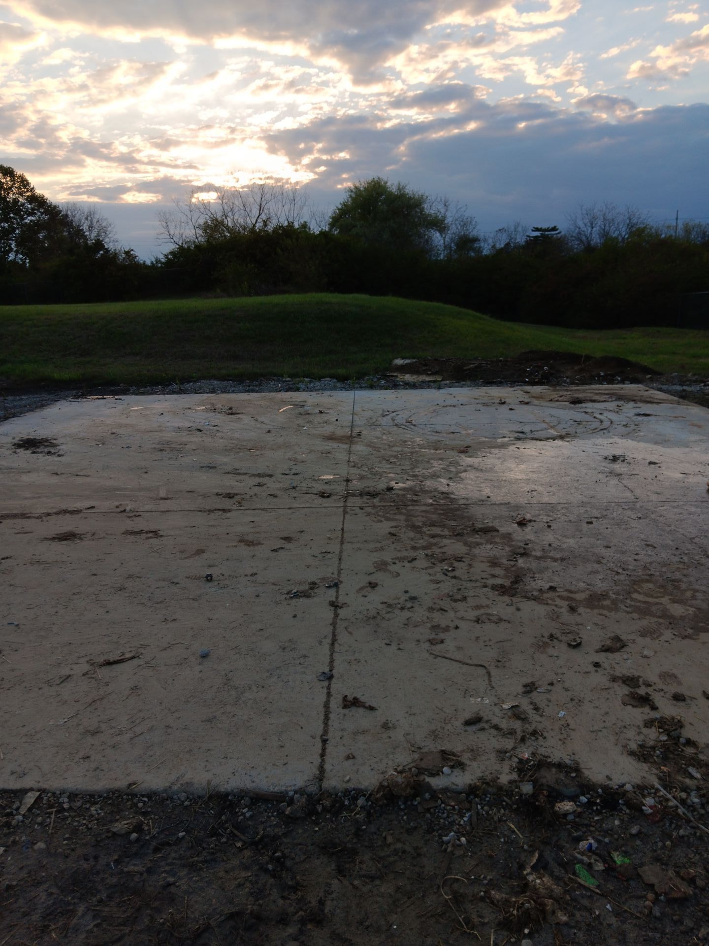 A muddy field with a sunset in the background