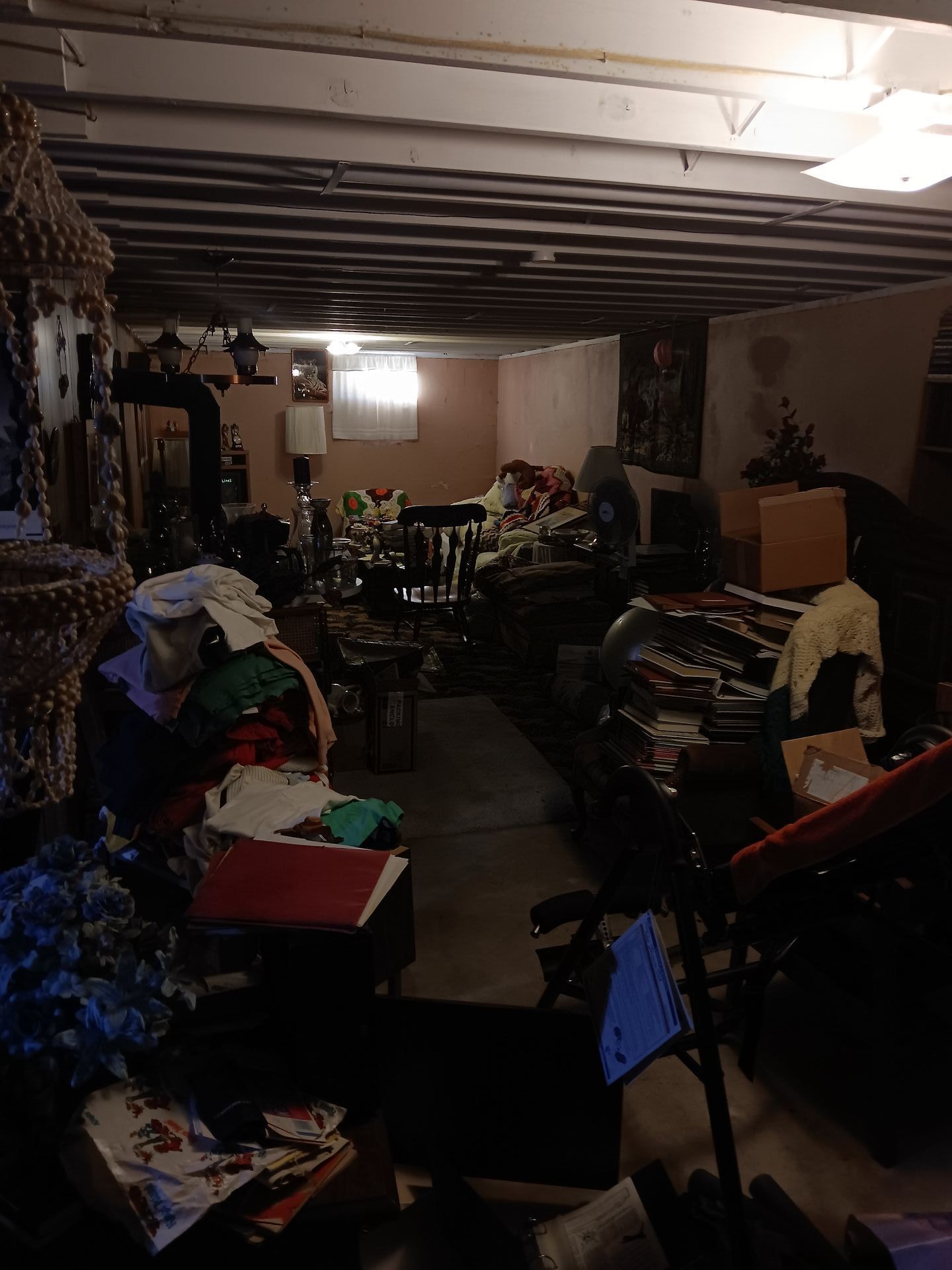 A basement filled with lots of furniture and clothes.