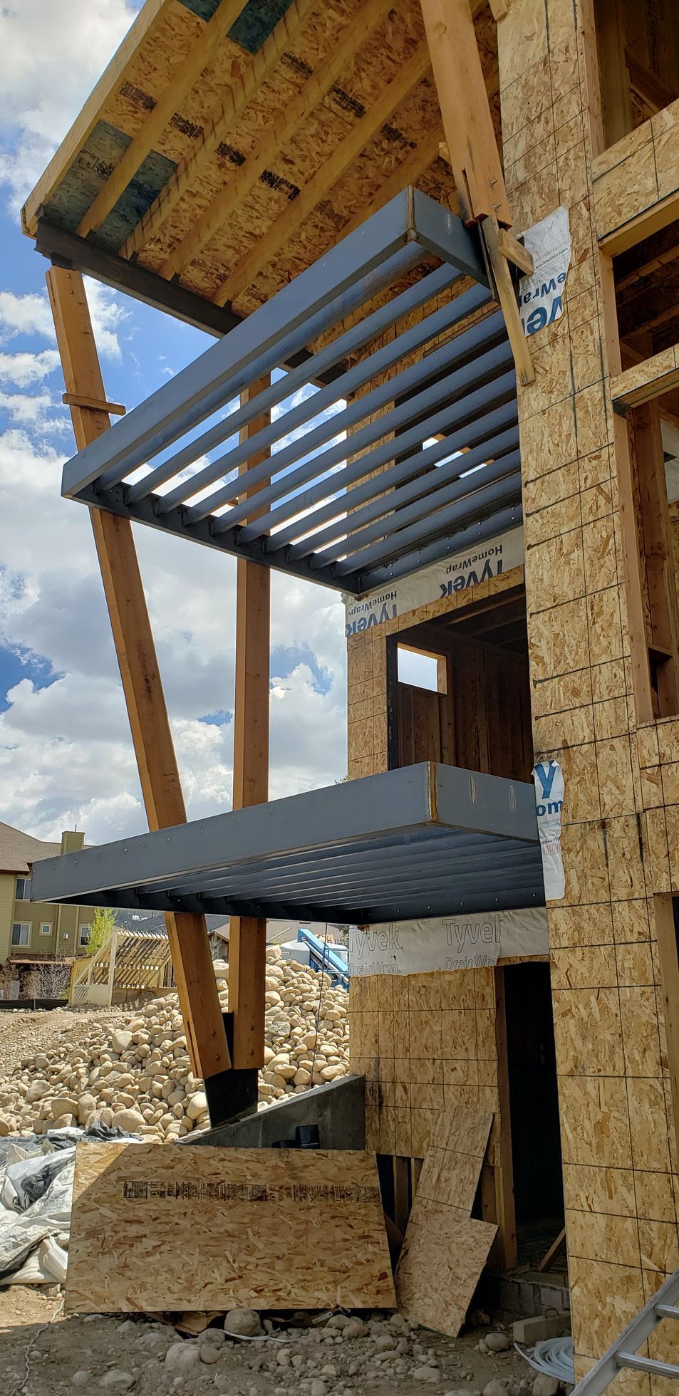 A wooden building under construction with a metal deck.