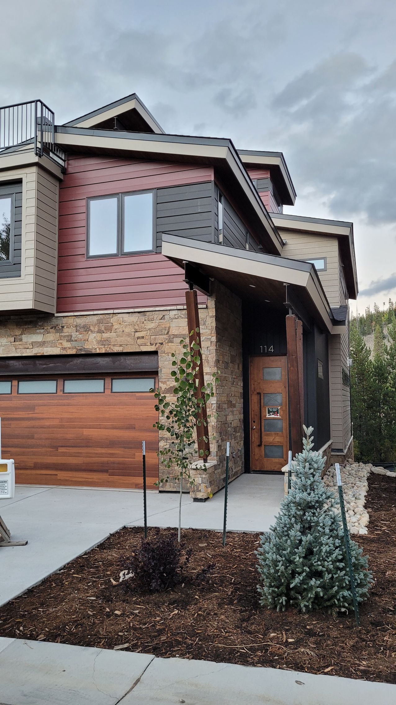 A large house with a wooden garage door is for sale.