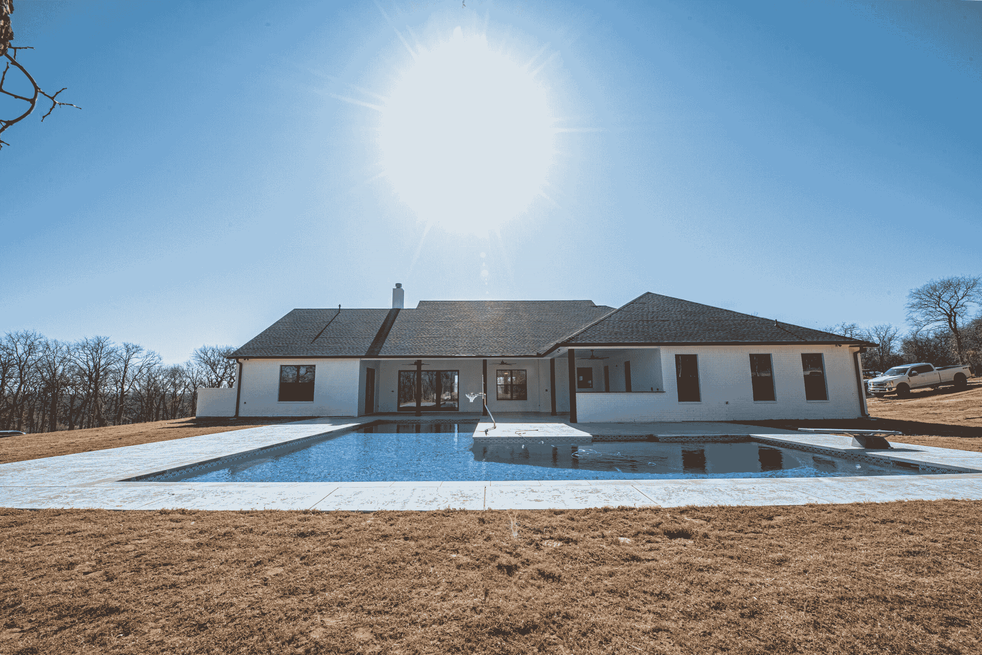 A large white house with a large swimming pool in front of it.