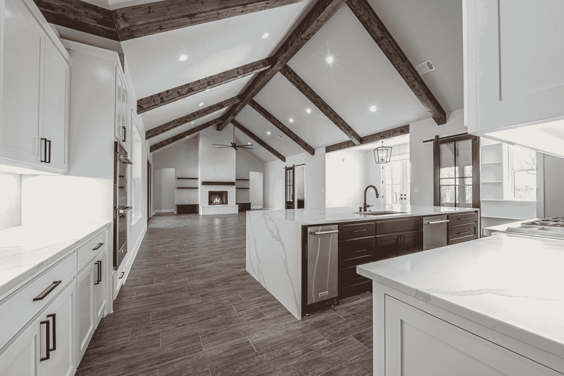 A kitchen with white cabinets and wooden beams on the ceiling.