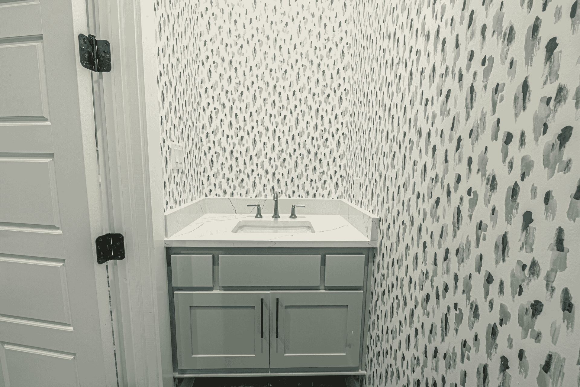 A bathroom with a sink and a leopard print wallpaper.