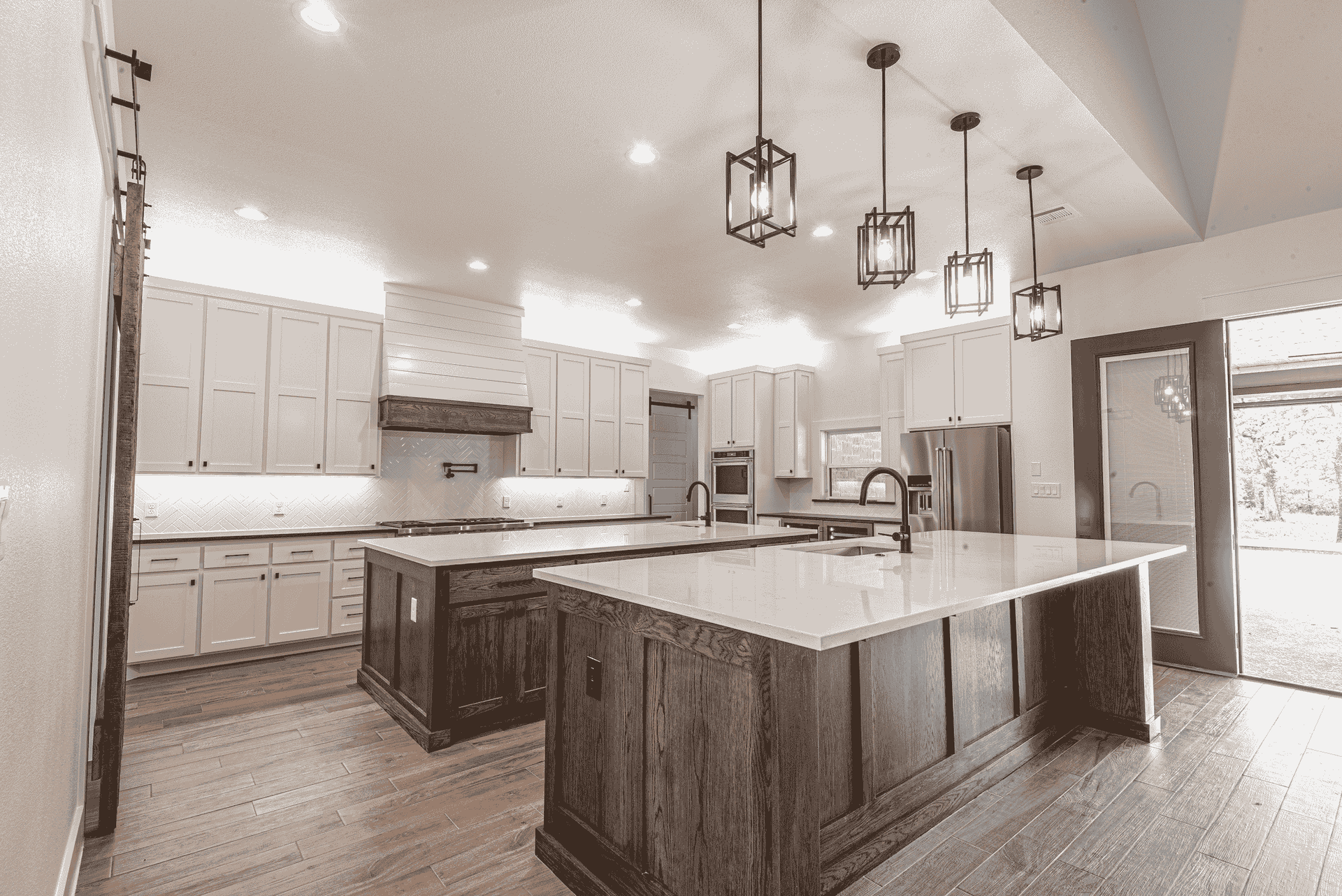 A black and white photo of a kitchen with a large island in the middle.