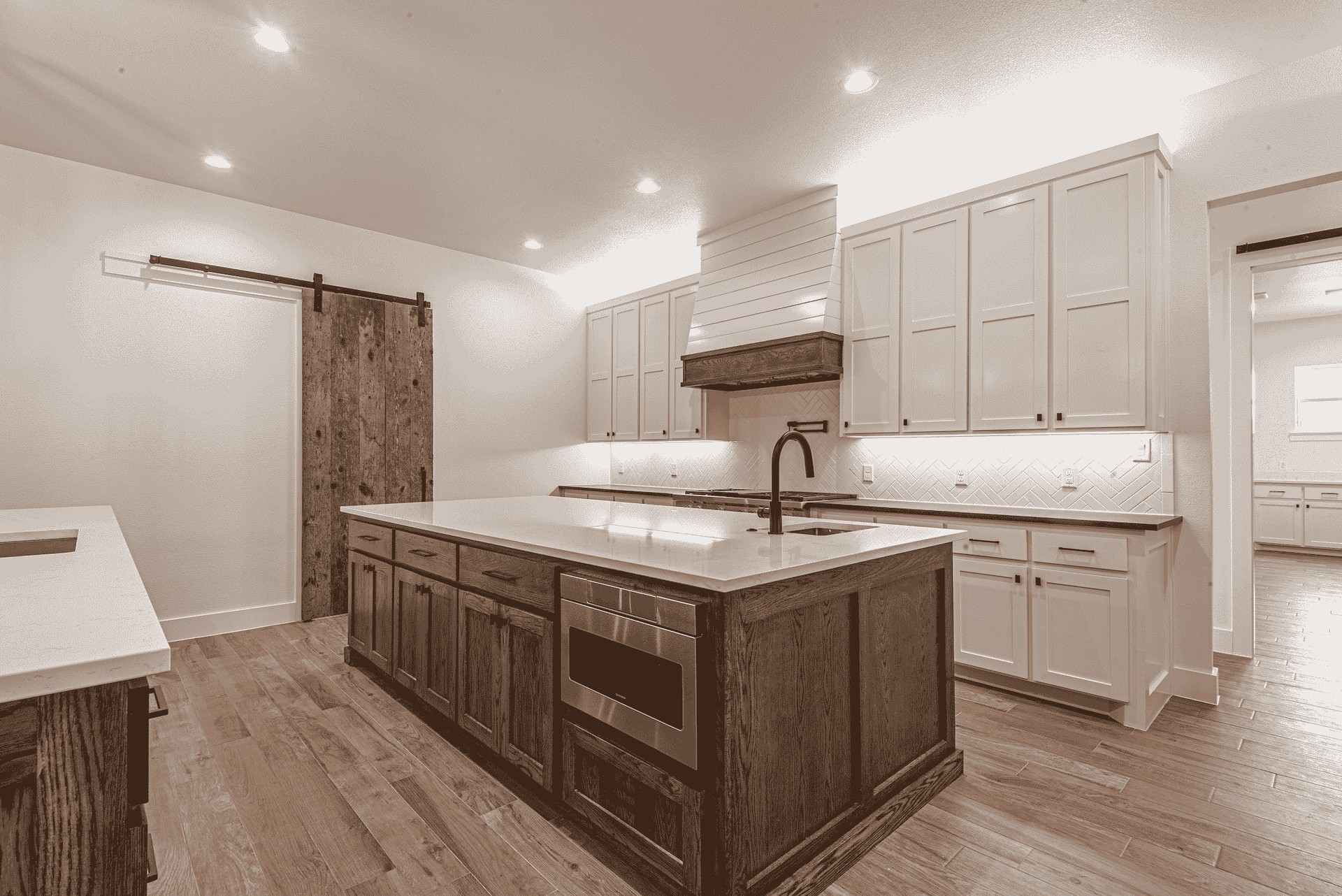 A kitchen with white cabinets and a large island in the middle.