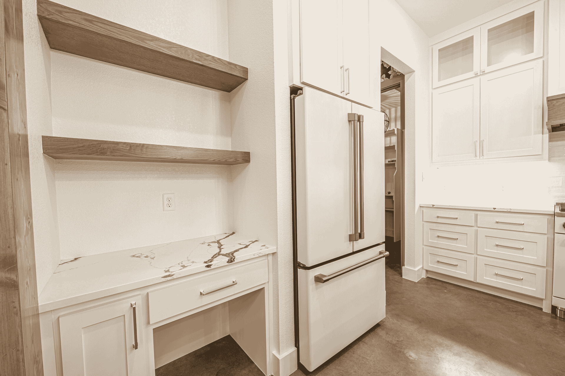A kitchen with white cabinets and a refrigerator.
