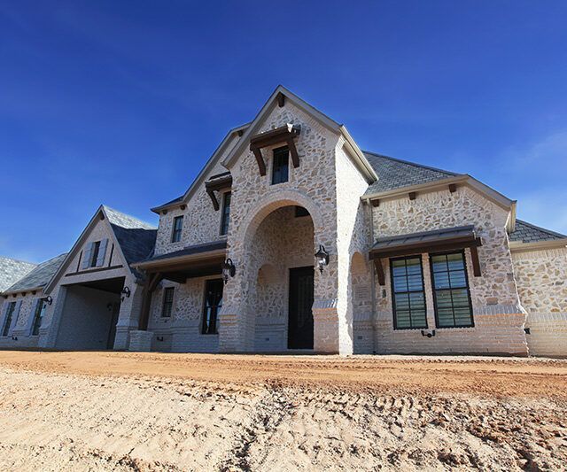 A large white house with a blue sky in the background