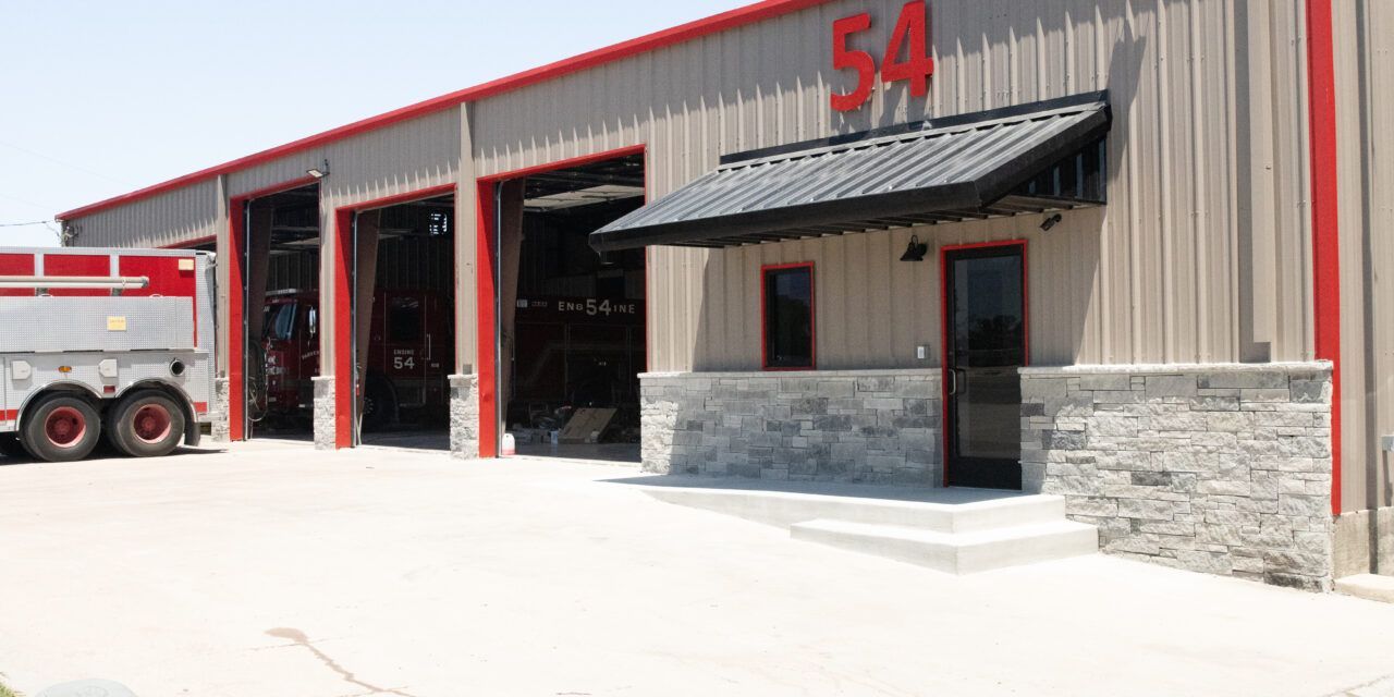 A fire truck is parked in front of a fire station.