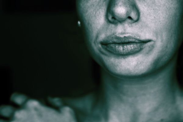 Close-up of a person's face, focusing on the nose, lips, and neck.