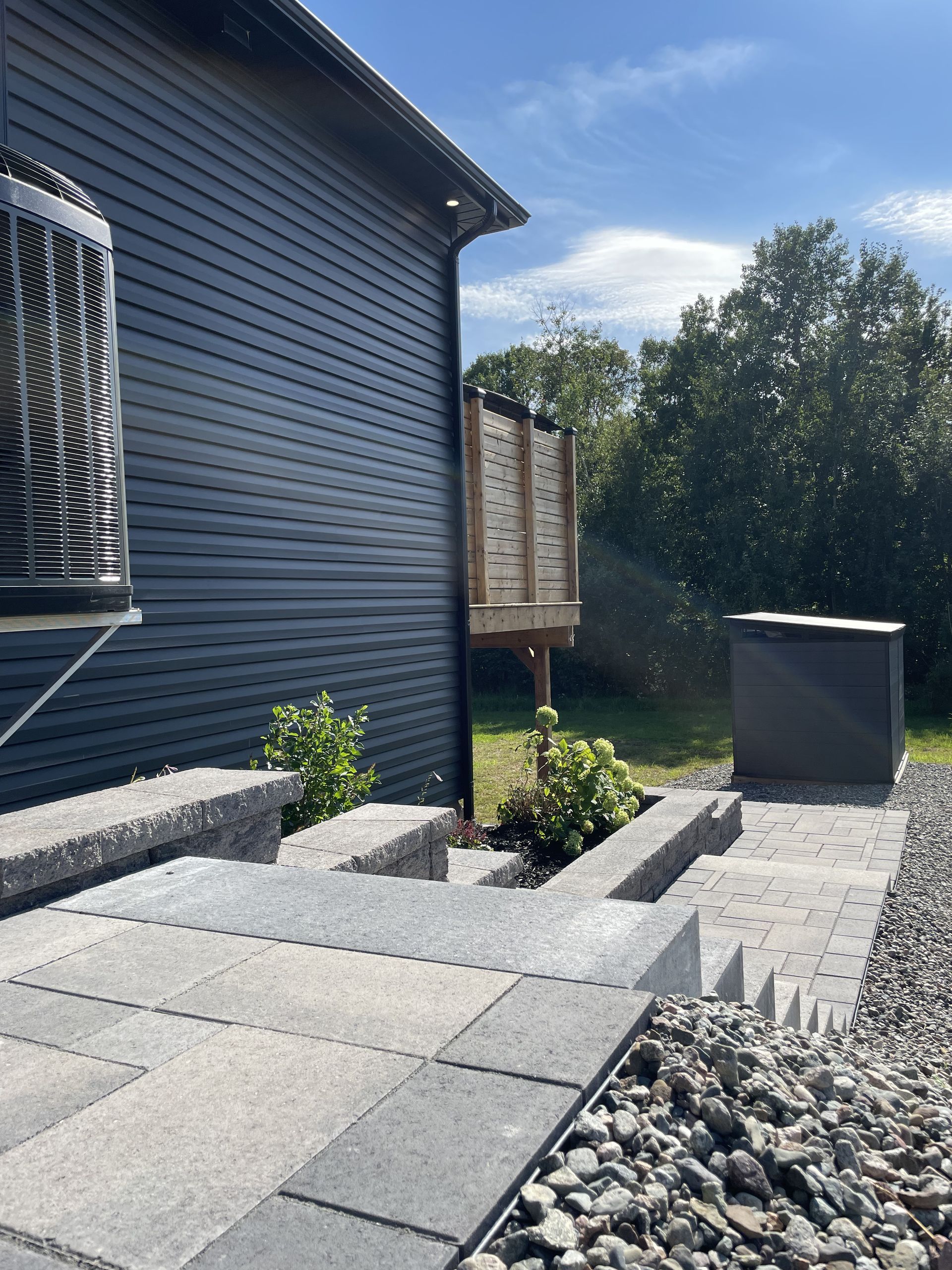 A black house with a patio and a fan on the side of it.